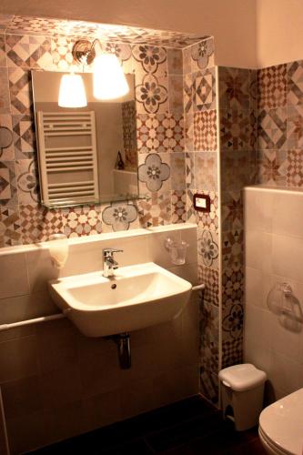 a bathroom with a sink and a mirror and a toilet at Le Dame Della Cortesella B&B in Como