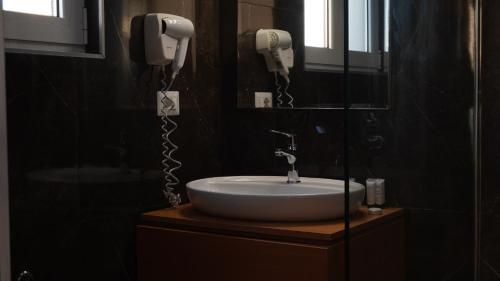 a bathroom with a sink and two phones on the wall at Hotel Miami II in Golem