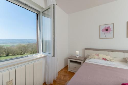 a bedroom with a bed and a large window at House FELICIA in Kršan