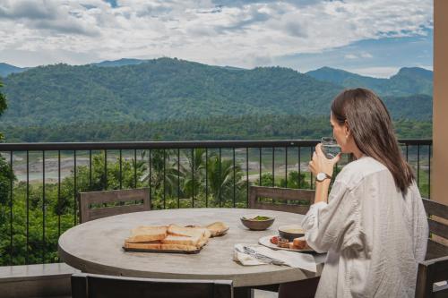 a woman sitting at a table with a glass of wine at Ishq Digana in Digana