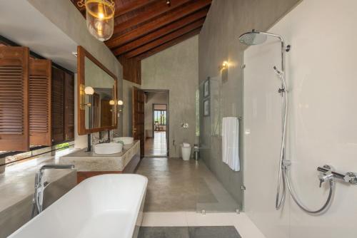 a bathroom with two sinks and a shower and a tub at Ishq Digana in Digana