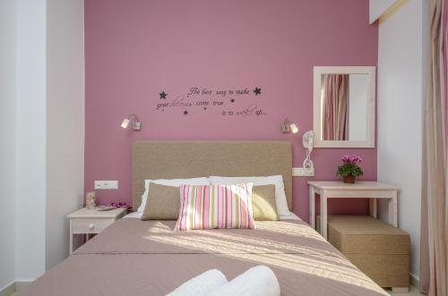a bedroom with a bed with a purple wall at Panormos Hotel and Studios in Naxos Chora
