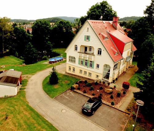 an aerial view of a large white house with a car at Penzion Jungmannova in Šluknov