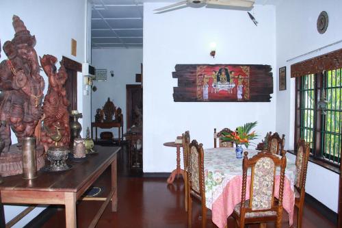 a dining room with a table and chairs in a room at Traditional Kandyan House in Kandy