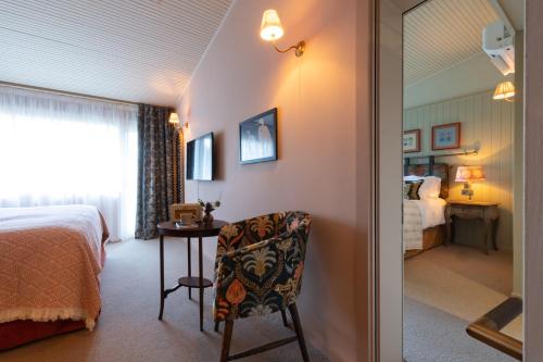 a room with a bed and a chair and a bedroom at The Potters Heron - A Heartwood Inn in Romsey
