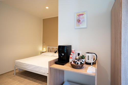 a small room with a bed and a table with at Locanda dell Angelo in Piacenza