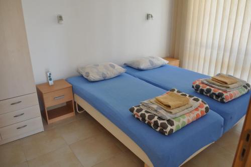 a bedroom with two twin beds with blue sheets at Villa Sun Village Byala in Byala