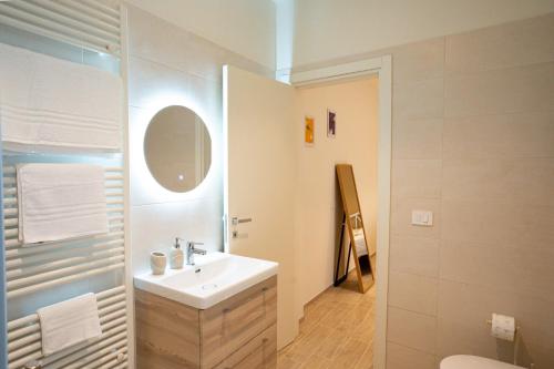 a white bathroom with a sink and a mirror at Locanda dell Angelo in Piacenza