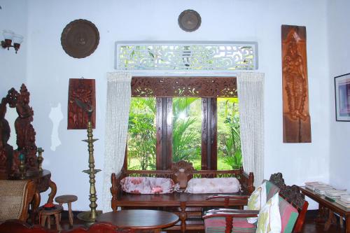 a room with a window and a table and chairs at Traditional Kandyan House in Kandy