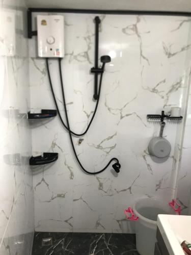 a shower in a bathroom with a white marble wall at Smiley Bungalows Guesthouse in Srithanu