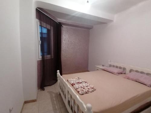 a bedroom with a bed in a room with a window at Les 4 chemins in Bejaïa