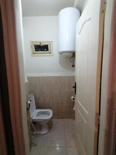 a small bathroom with a toilet and a window at Les 4 chemins in Bejaïa