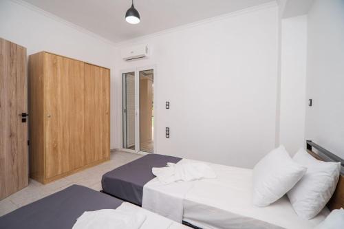 a bedroom with two beds and a wooden cabinet at Villa Pasiphae by PosarelliVillas in Vamos