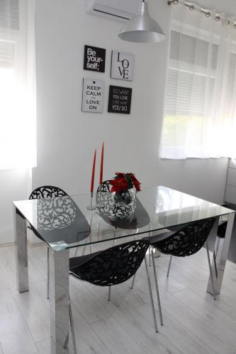 a glass table with two chairs and a vase with flowers at Ka Star in Karlovac