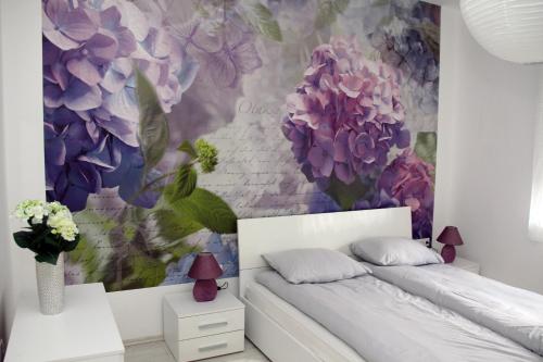 a bedroom with a bed and a flower mural at Ka Star in Karlovac