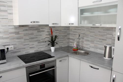 a kitchen with white cabinets and a sink at Ka Star in Karlovac