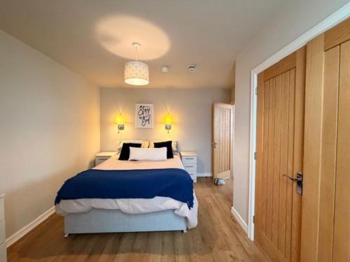a bedroom with a large bed with blue and white sheets at Stay in Blackpool