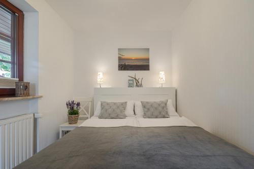a white bedroom with a large bed in it at Dünensand in Süderende