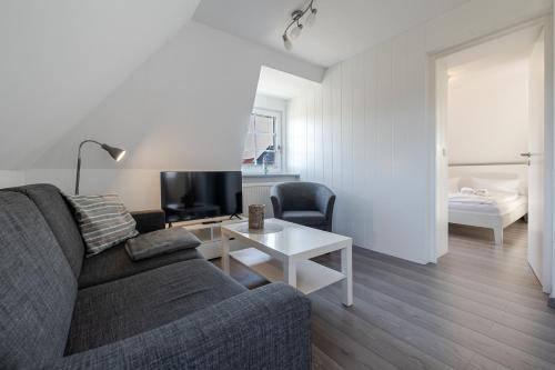 a living room with a couch and a table at Sonnenaufgang in Süderende