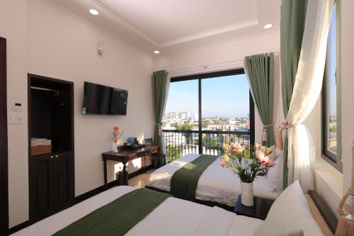 a bedroom with two beds and a window with a view at APT Hotel Phan Rang in Phan Rang–Tháp Chàm