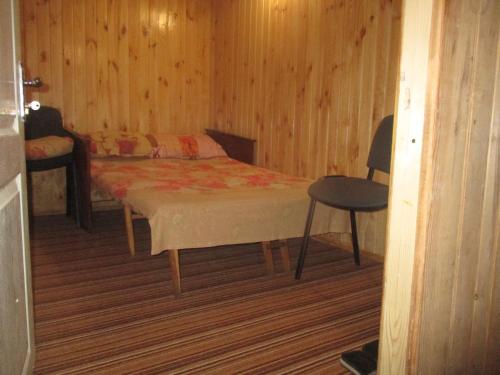 een slaapkamer met een bed, een tafel en een stoel bij Pershyy Hostel u Cherkasah in Tsjerkasi