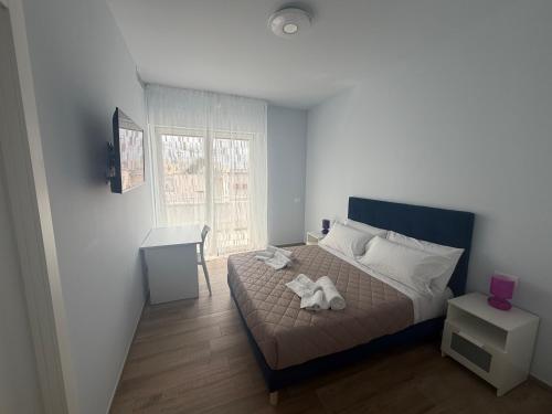 a bedroom with a bed and a table and a window at Vale House in Monopoli