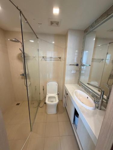 a bathroom with a toilet and a sink and a shower at City Garden Olympus Premier By Vacation Vibes in Pattaya South
