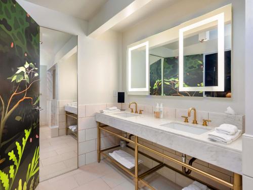 a bathroom with a sink and a mirror at 21c Museum Hotel Bentonville - MGallery in Bentonville