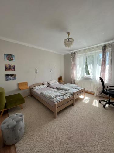 ein Schlafzimmer mit einem Bett und einem Stuhl in der Unterkunft AgroKrówka - Agroturystyka w Niecieczy in Nieciecza