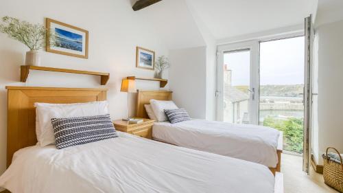 two beds in a room with a window at Thalassa in Cemaes Bay