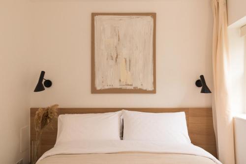 a bedroom with a bed with a painting above it at Bright Japandi 1BR Flat with Garden - Central Oxford in Oxford