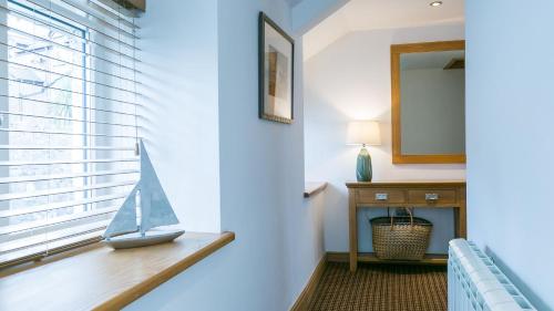 a toy sailboat sitting on a window sill in a room at Thalassa in Cemaes Bay