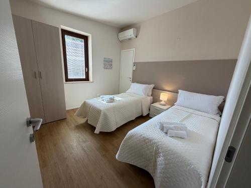 a bedroom with two beds and a window at Corte Al Lago in Moniga