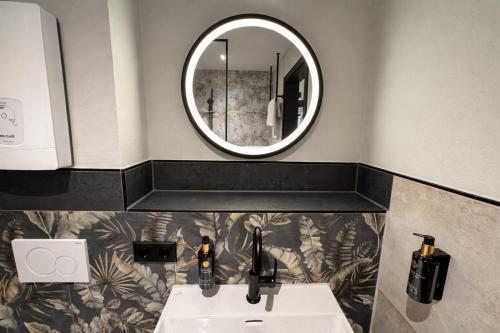 a bathroom with a sink and a mirror at Parzivita Suites in Wolframs-Eschenbach