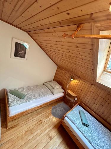 a small room with two beds in a attic at Pferdehof Almgut - Reiten für Kinder, Natur und Erholung nahe Salzburg in Faistenau