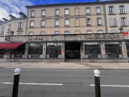 a large building on a city street with a store at The Originals Boutique, Grand Hôtel Saint-Pierre, Aurillac in Aurillac