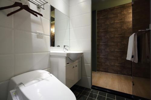 a bathroom with a white toilet and a sink at Buckingham Palace B&B in Beipu