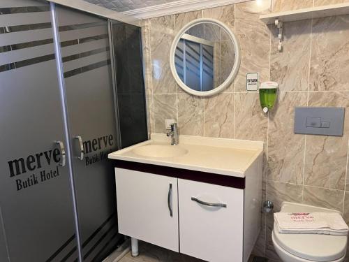 a bathroom with a sink and a toilet and a mirror at MERVE BUTİK OTEL in Didim