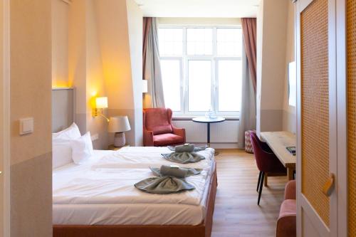a hotel room with a bed with two towels on it at Hotel Germania in Bansin