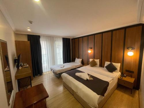 a hotel room with two beds and a television at Taksim Nu Pera Hotel in Istanbul