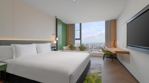 a hotel room with a large white bed and a desk at EVEN Hotel Xi'an High-Tech Zone by IHG in Xi'an