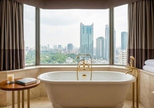 a bath tub in a room with a large window at Con Vanh Hotel in Bằng Viên