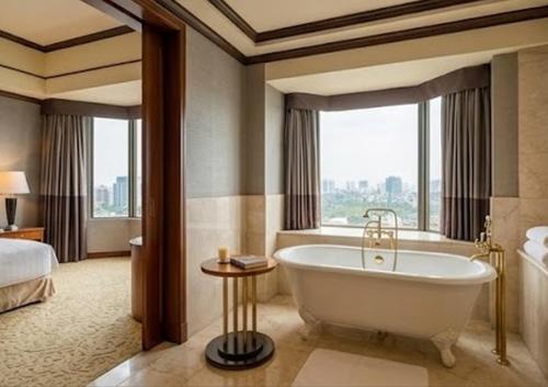a bathroom with a tub in a hotel room at Con Vanh Hotel in Bằng Viên