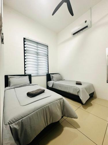 a bedroom with two beds and a window at The Luxe Permata by Haffa in Lunas