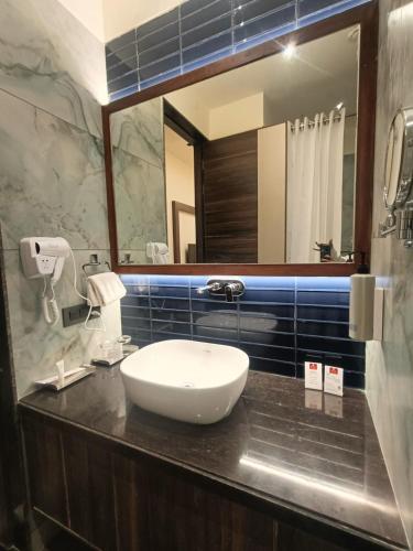 a bathroom with a sink and a mirror at Lords Swastik Studio Kodinar in Kodīnar