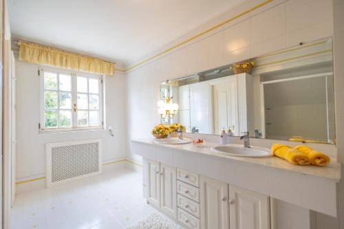 a bathroom with two sinks and a large mirror at Villa familiar - Jacuzzi - Children's Area in Bacoy