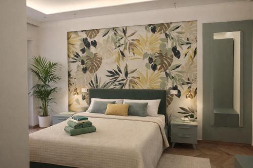 a bedroom with a large bed with a floral wallpaper at B&B Capo Rizzuto Armenes in Capo Rizzuto