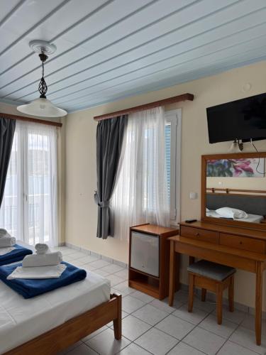 a bedroom with two beds and a desk and a television at Poseidon in Ancient Epidauros