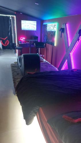 a bedroom with a bed with purple and green lights at Love room les pins in Le Muy