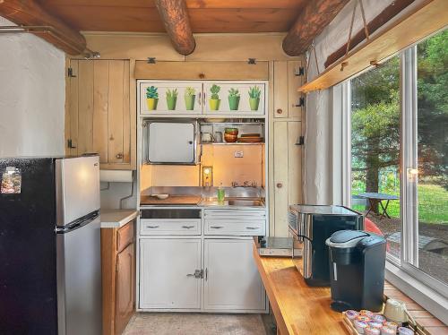 a kitchen with white cabinets and a black refrigerator at Casita Adobe in Grand Junction